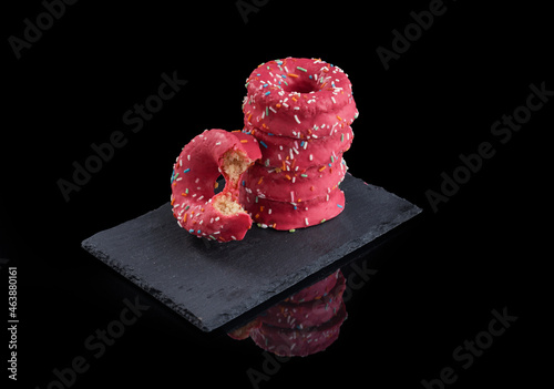 torre de donuts encima de un plato de pizarra sobre fondo negro e instrumental de dentista