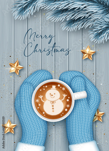 Hands in knitted mittens holding a cup of coffee. Christmas greeting card template
