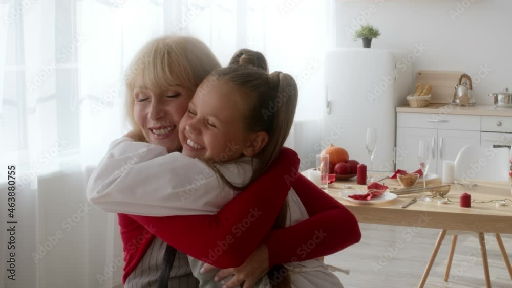 Happy Grandma Hugging And Kissing Granddaughter Celebrating Holiday At Home Happy Grandma Hugging And Kissing Granddaughter Celebrating Holiday At Home