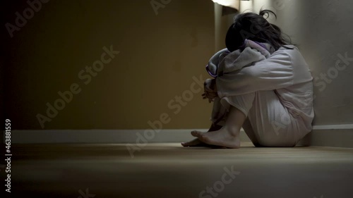 Squat Kid sit near window, sad lonely in dark night indoor, crying, bad mood, offended, consoles,  concept of unhappy childhood, life together photo
