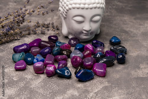 Feng Shui altar at home in living room. Attracting wealth, prosperity concept. Crystal clusters. Buddha figure on the table. Face of Buddha and stones of ametist on old wooden background. Meditation photo