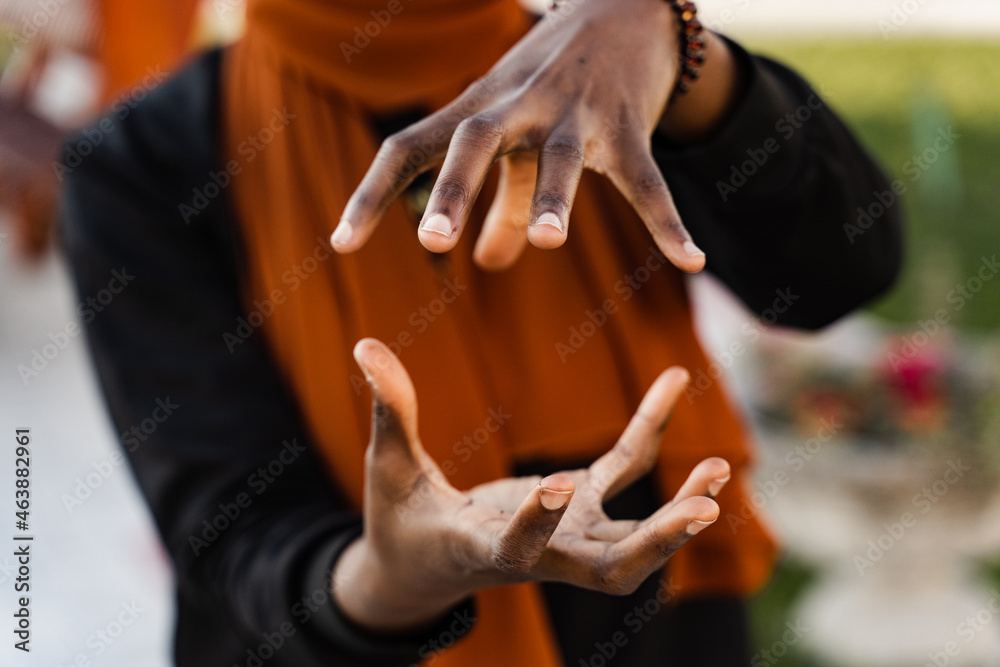 Close-up hands of black muslim woman at qigong chinese meditation and sport training outdoor. African girl is meditating outdoor near chinese arbor.
