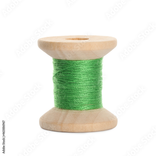 Wooden spool of light green sewing thread isolated on white photo