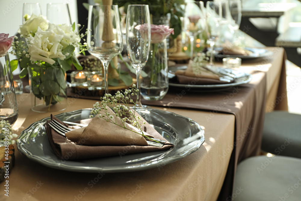 Festive table setting with beautiful tableware and floral decor in restaurant Festive table setting with beautiful tableware and floral decor in restaurant