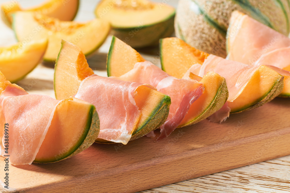 Italian prosciutto ham with melon. Slices of traditional ham wrapped around cantaloupe melons. Italian prosciutto ham with melon. Slices of traditional ham wrapped around cantaloupe melons.