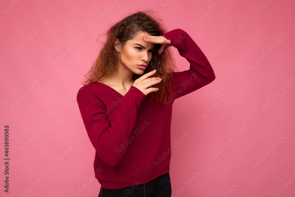 Portrait of young serious beautiful brunette curly woman with sincere emotions wearing trendy pink pullover isolated on pink background with copy space and grimacing having fun Portrait of young serious beautiful brunette curly woman with sincere emotions wearing trendy pink pullover isolated on pink background with copy space and grimacing having fun