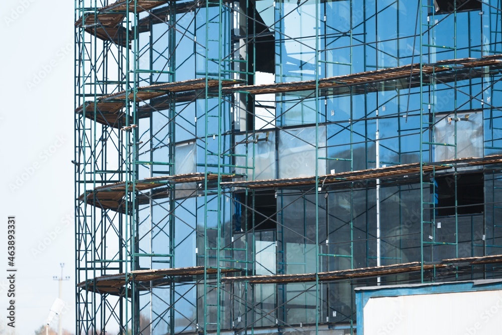 Crane and building under construction against blue sky Crane and building under construction against blue sky