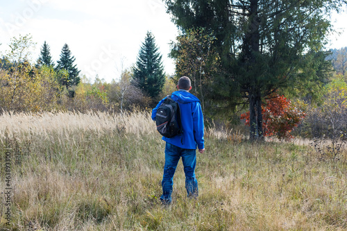 Man with a backpack stay in autumn forest 