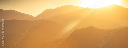 Sunset or sunrise on a mountain background. Silhouette of mountains. Black and orange panorama nature background.