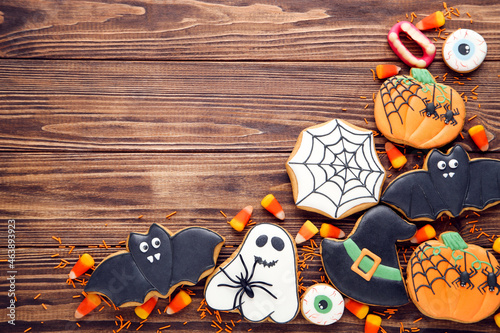Halloween gingerbread cookies with candies on brown wooden table