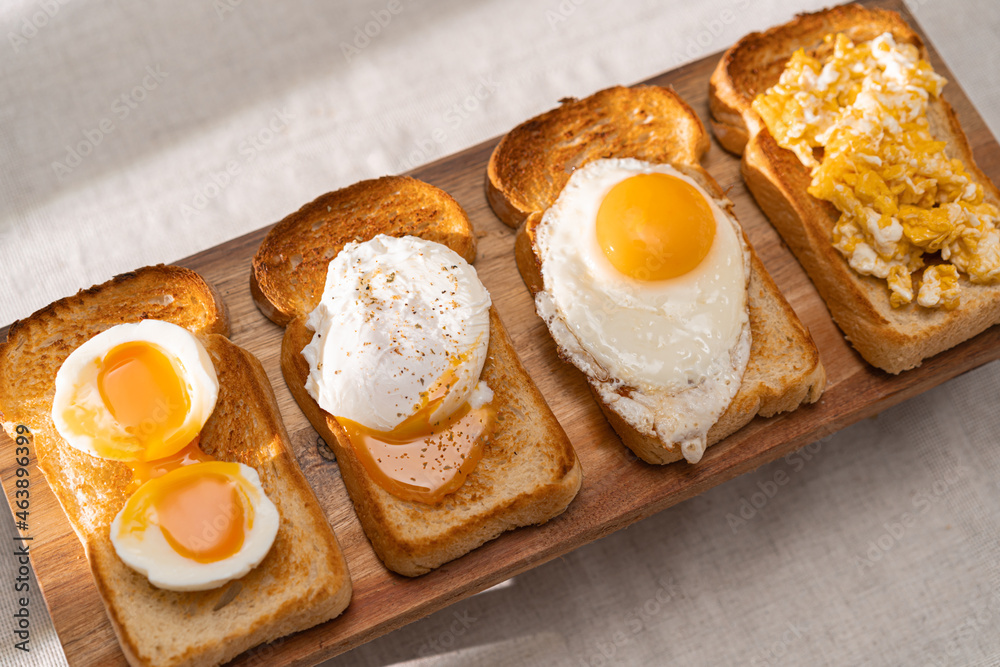 fried Toast bread with four different types of cooked chicken eggs, scrambled eggs, fried eggs, poached egg and creamed egg. Breakfast of chicken eggs. methods of making eggs for breakfast