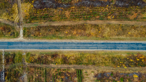 Aerial top down view of countryside asphalt road at autumn. Autumn colors. Nature