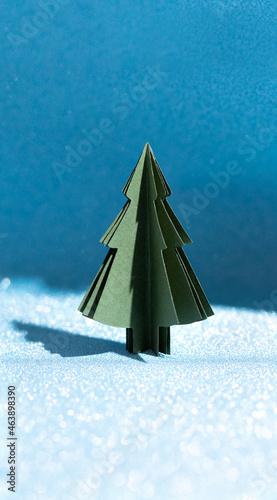 Christmas tree made of paper on a shiny blue background. Crafts by hand. Evening forest © Nizoli