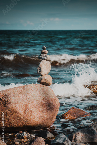 Meditation zen stones stacked at a wild beach on a perfect sunny summer day with ocean background. Fehmarn at the German Baltic Sea in Germany