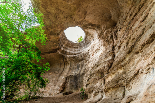  A hole from which the sun's rays and the sky are visible outside of an underground cave, an abnormal natural phenomenon in the rocks in the Crimea