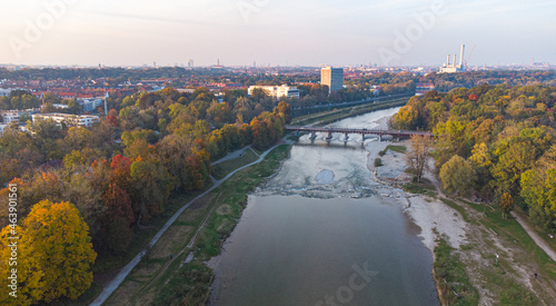 Aerial view of Isar river flowing into Munich and Thalkirchen bridge with cars in a beautiful autumn landscape