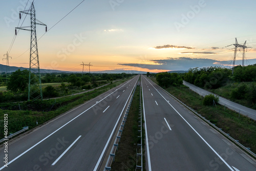 Empty silent Freeway. Asphalt highway road with beautiful sunset sky in pastoral rural environment