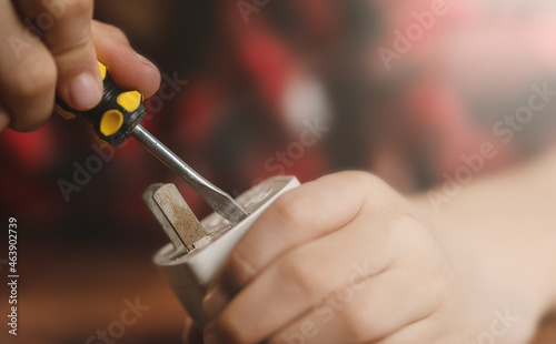 A girl is repairing an electrical appliance and sockets.