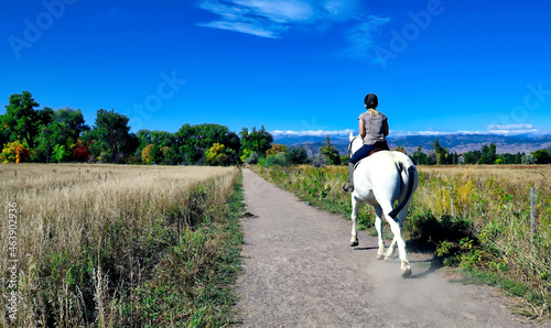 Woman riding a white horse near Boulder, Colorado © Jim Glab