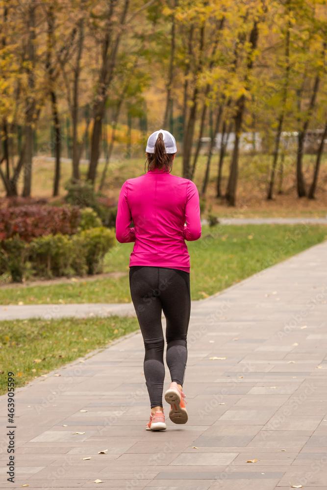 The girl runs in the park. The running Man. Work on yourself. What to do in the fall. Weight loss cardio workout. Improving the figure. Workouts without a gym. Healthy lifestyle.