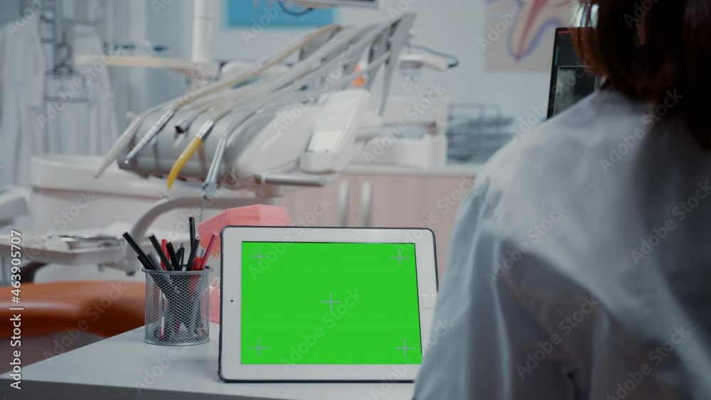 Close up of digital tablet with horizontal green screen on desk in dentistry cabinet. Dentist analyzing isolated template and mockup background with chroma key for stomatological care Close up of digital tablet with horizontal green screen on desk in dentistry cabinet. Dentist analyzing isolated template and mockup background with chroma key for stomatological care