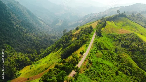Aerial footage of winding road in rainy season on tropical rainforest mountain in Nan province, Thailand. 4K resolution drone footage top view.