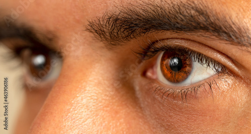 Macro photo of brown skinned man with brown eyes. photo