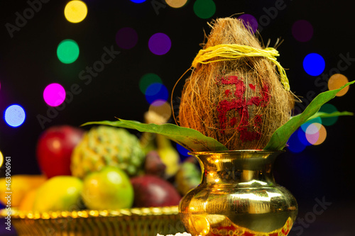 Brass Pot Kalash Decorated With Coconut, Mango Leaf and plate of fruits. Used In Navratri Pooja, Dussehra Puja, Karva Chauth, Teej, Ganesh Chaturthi Or Shubh Deepavali, grih or grah pravesh photo