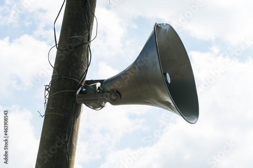 Old megaphone on pole full of cables
