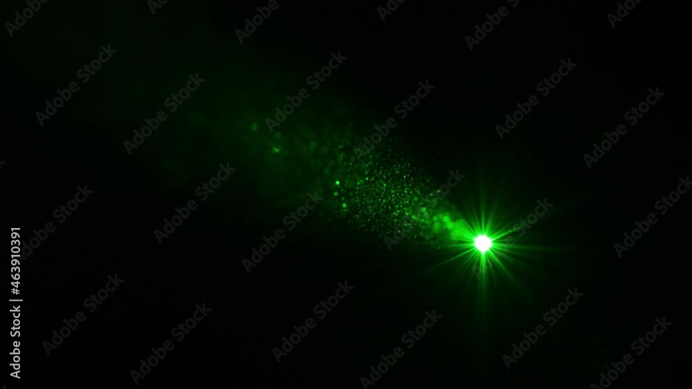 The green laser ray shining on a black background. slow motion