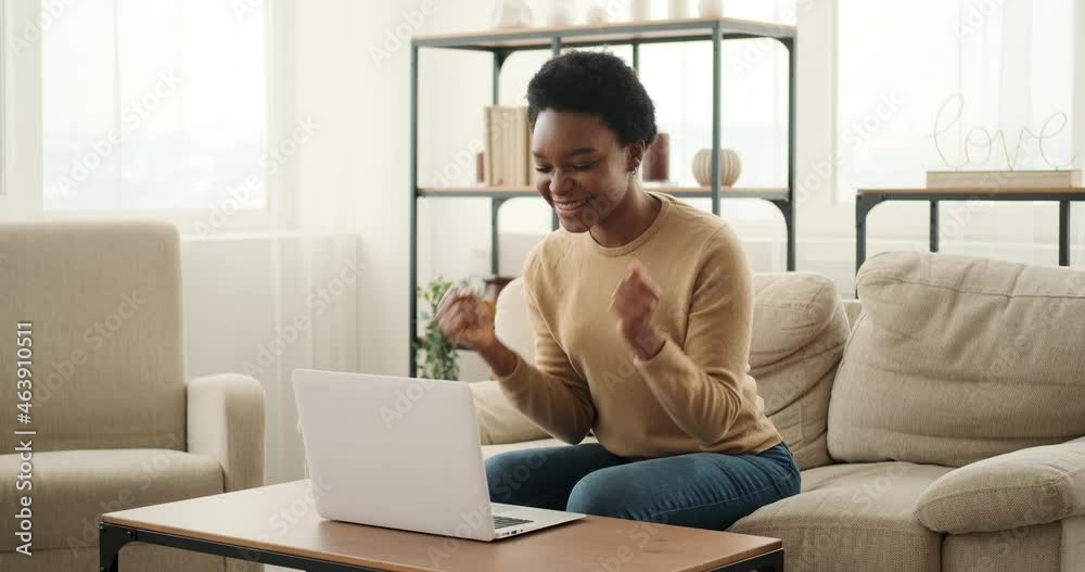 Delighted woman using laptop and celebrating success holding a bundle of cash dollars Delighted woman using laptop and celebrating success holding a bundle of cash dollars