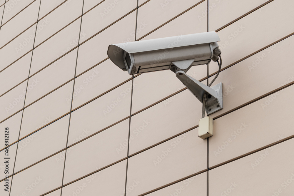 Close-up CCTV camera on the wall of the building Close-up CCTV camera on the wall of the building