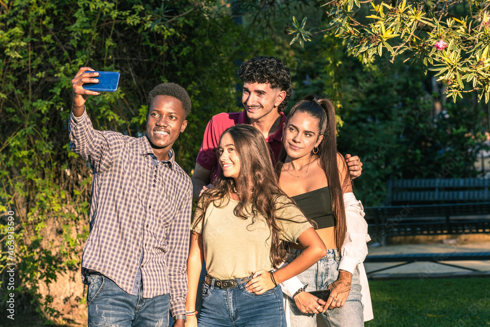 Group of multiethnic friends taking a selfie with a mobil standing in a park