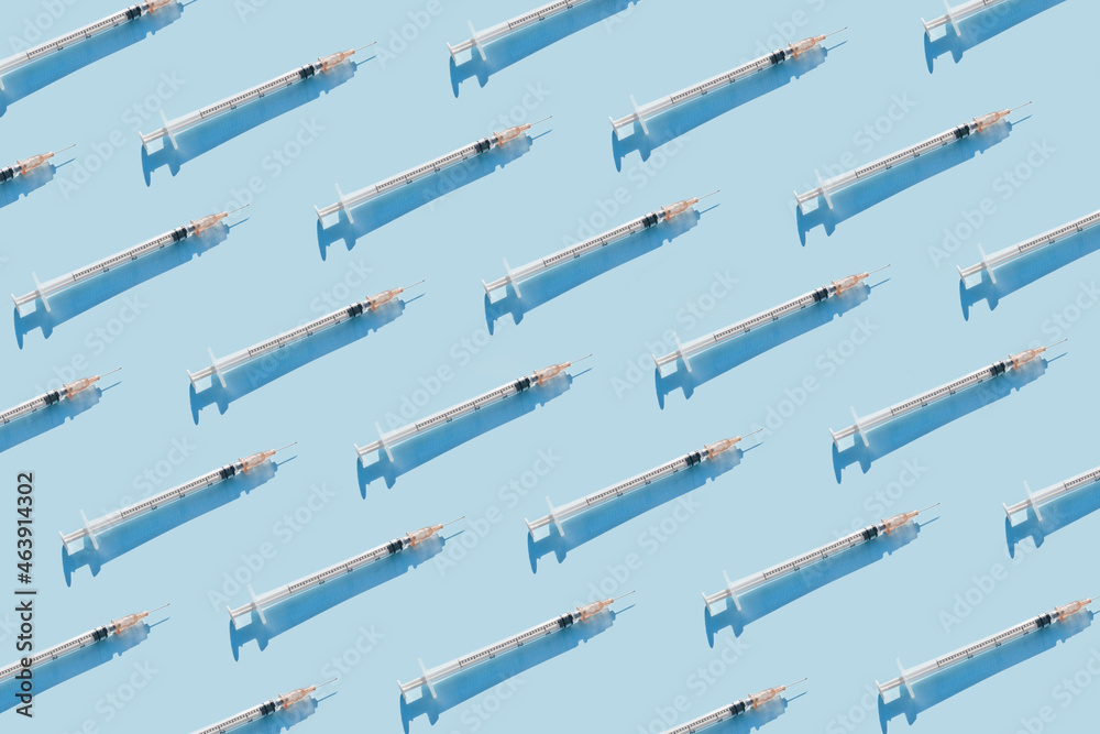 Creative medicinal pattern from syringes of blue background. Colorful concept of Corona virus 2019-nCoV or COVID-19 vaccine. Flat lay, top view