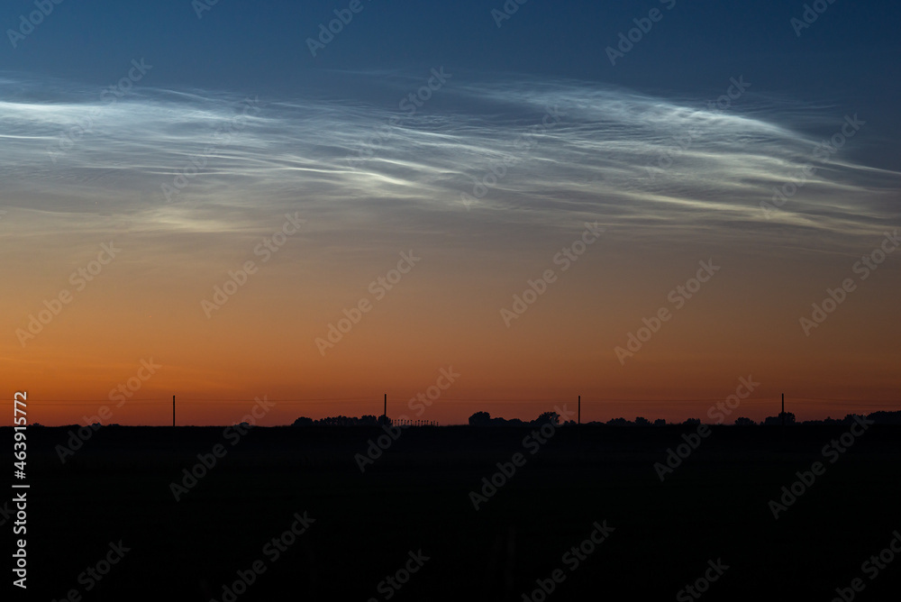 Display of noctilucent clouds or NLC in the northern sky on a clear evening in June Display of noctilucent clouds or NLC in the northern sky on a clear evening in June