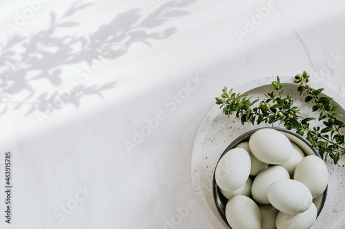 Easter flat lay with green eggs on a white marble