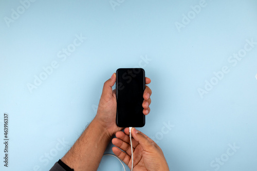 Close up photo of a hand charging mobile phone