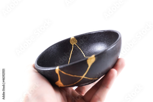 Fotografie Isolated Japanese kintsugi black bowl restored with real gold , black pottery wi