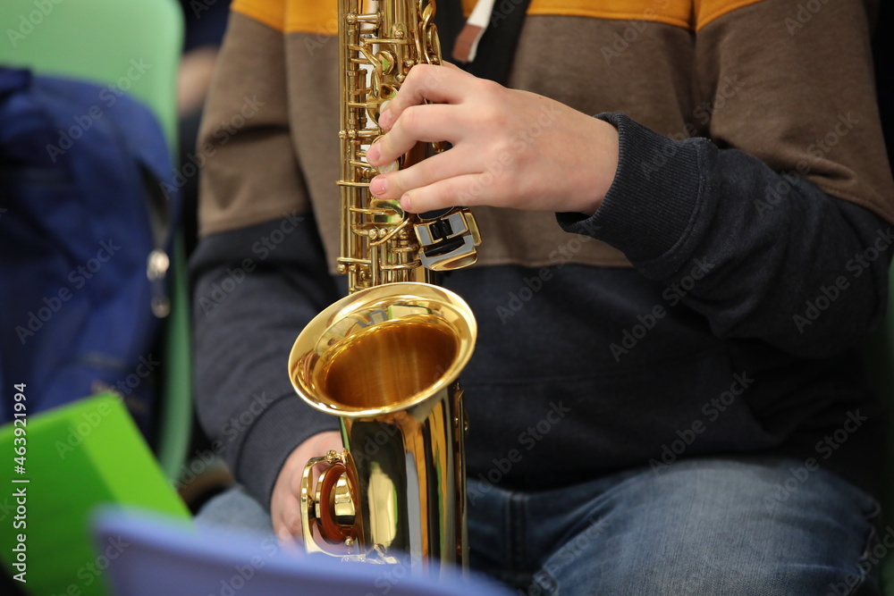 Obraz premium Person in jeans playing saxophone background image jazz concept