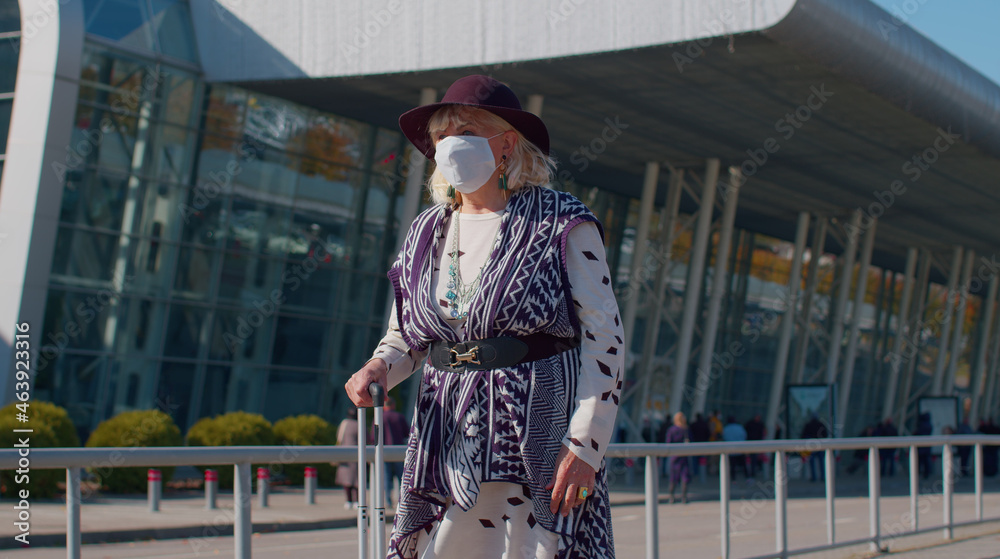 Senior old pensioner tourist female grandmother businesswoman wearing Protective Face Mask, avoid disease COVID-19 coronavirus infection near airport pandemic disease virus epidemic air health illness