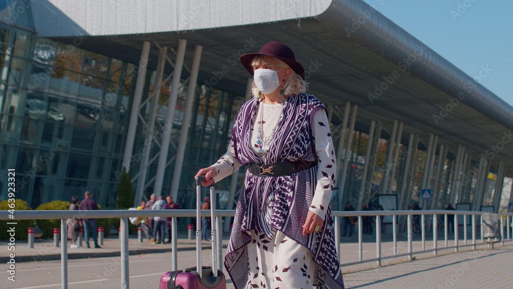 Portrait one unhappy old senior woman grandmother businesswoman wearing Protective Face Mask COVID-19 coronavirus infection near airport pandemic disease virus tourist, epidemic illness, slow motion.