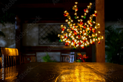 defocused Christmas lights reflected on wooden table