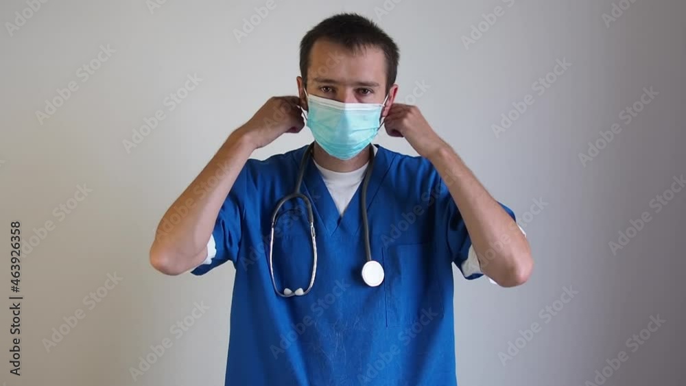 Serious tired doctor man looking at camera and taking off mask medical and stetoskop and do away. Copy space for text 