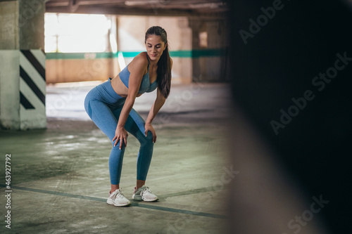 Attractive young woman doing fitness exercises while training outside