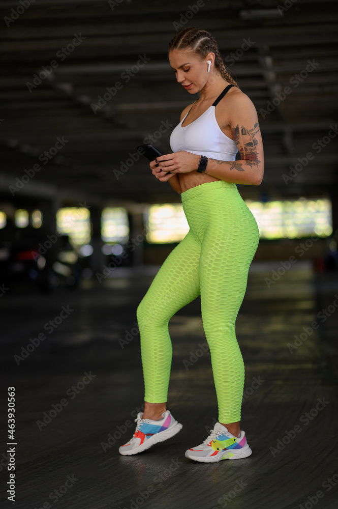 Woman using smartphone and airpods after finishing her training outside Woman using smartphone and airpods after finishing her training outside