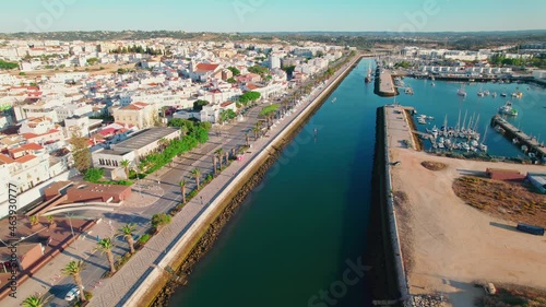 Aerial view of Marina de Lagos and Lagos town centre with buildings and houses. Restaurants, Hotels and holiday destinations in Algarve, Portugal from above. Luxury and scenic vacation city in 4K.