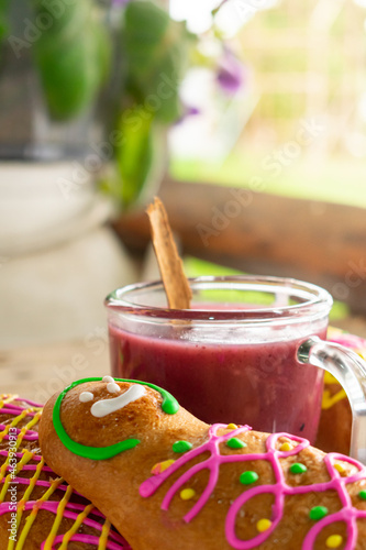 Traditional guaguas de pan with colada morada, a typical ecuadorian dish that includes doll shaped bread for the day of the dead. Rustic blurry background. Latin america gastronomy and culture.