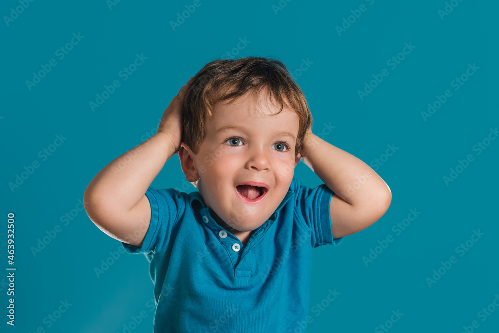 Close-up of a little boy putting his hands on his head in surprise Close-up of a little boy putting his hands on his head in surprise