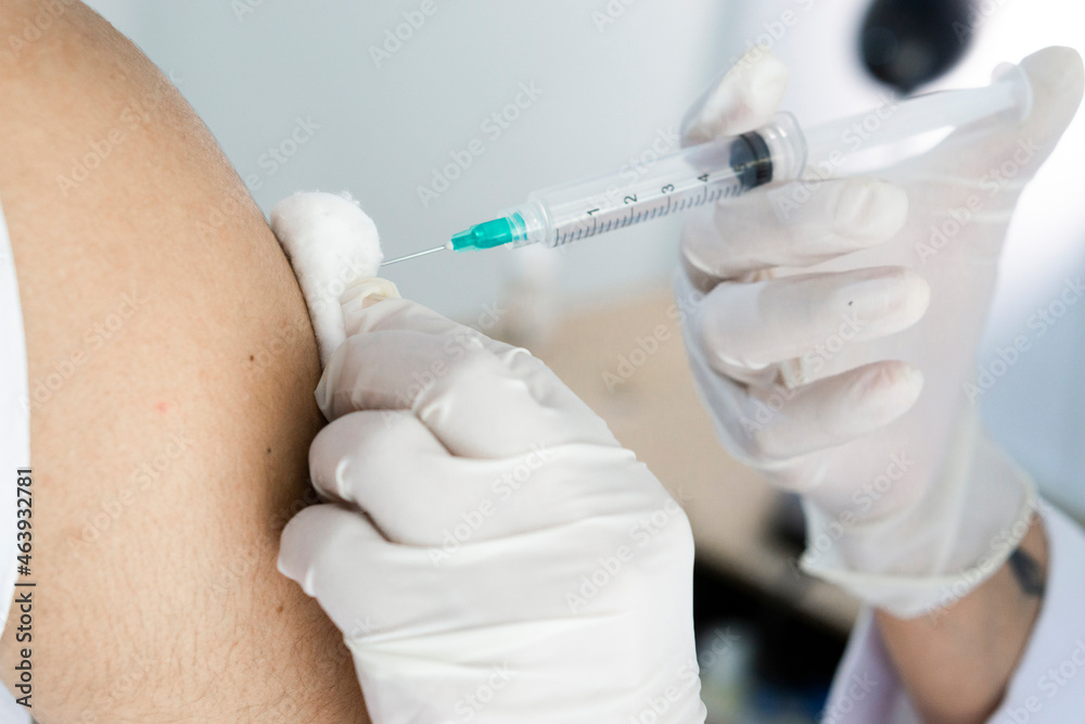 Hand with a syringe injecting an arm. Health care.