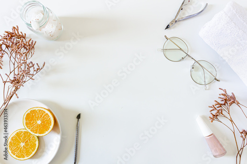 Health care spa concept. Mock up with dried flowers, glasses, orange slices, nails cutters, towel and bath salts on white background. Flat lay, top view. Beauty, skin care, composition.